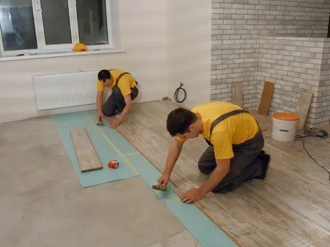 Builder installing laminate flooring