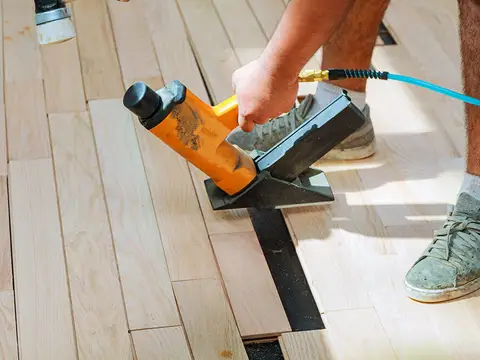 Carpenter installing wood parquet flooring