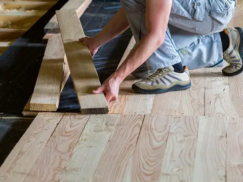 Close-up of a carpenter installing natural timber flooring